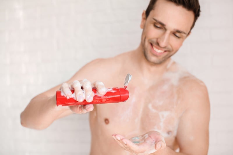 Handsome man taking shower at home