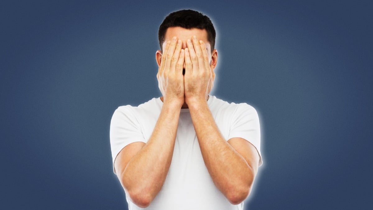 Life Sucks Man in White Shirt Holding Hands Over Face Blank Background