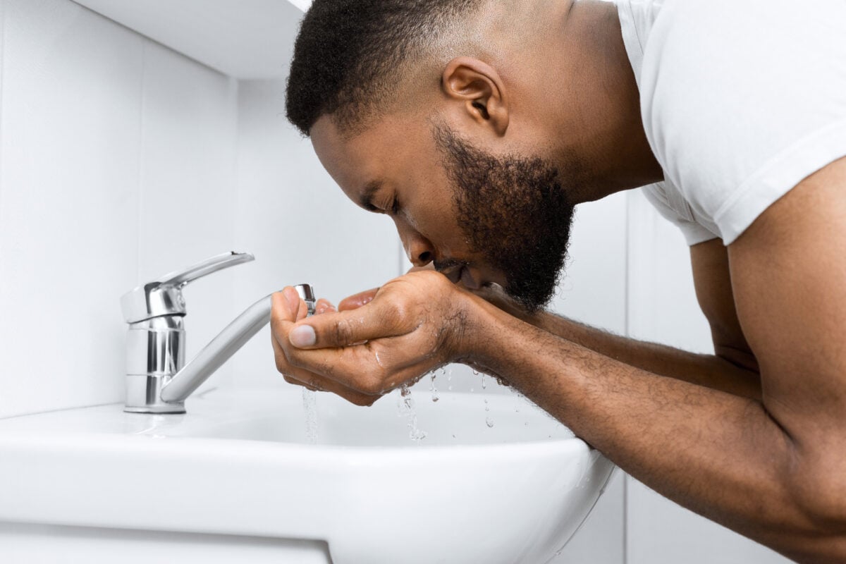 Man washes his face