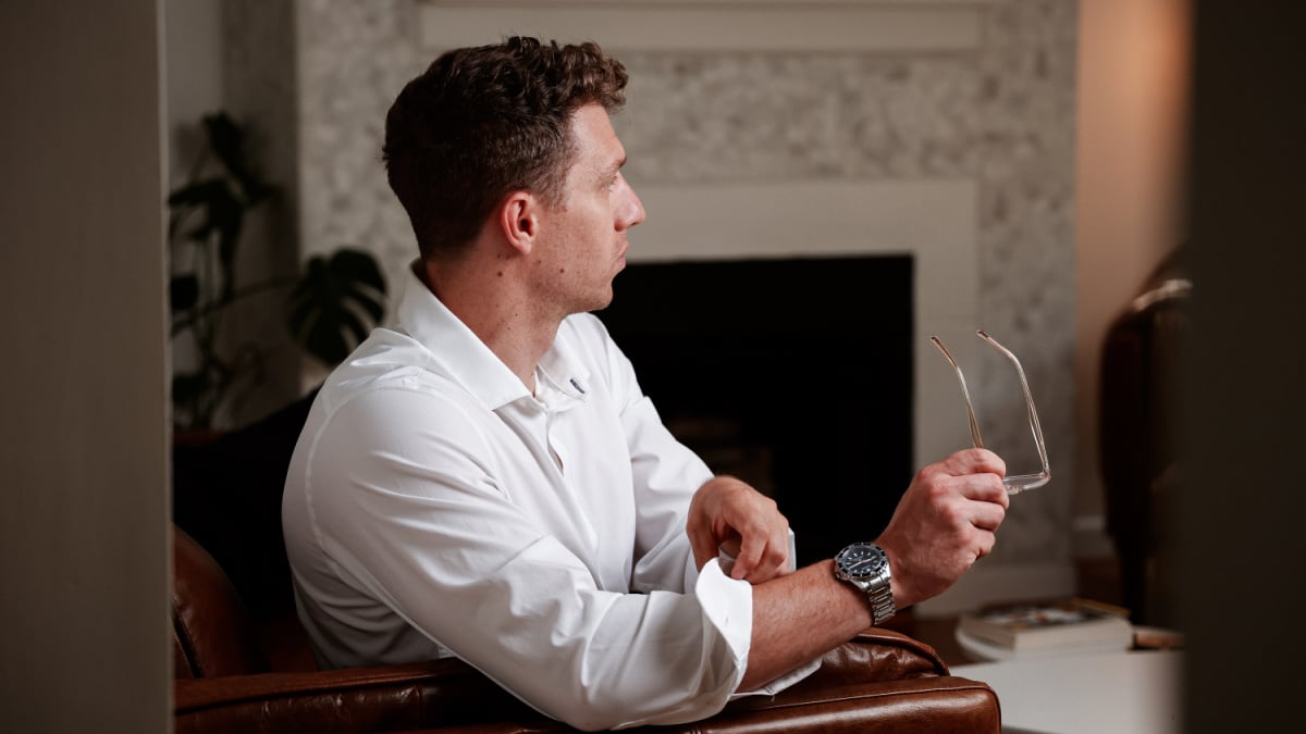 Mizzen and Main Review Model Wearing White Leeward Dress Shirt and Holding Glasses