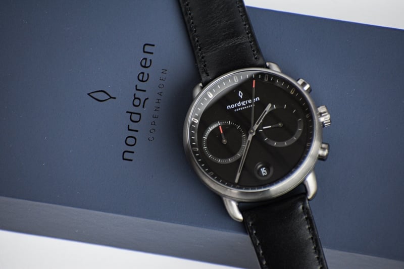 nordgreen pioneer black dial against blue packaging