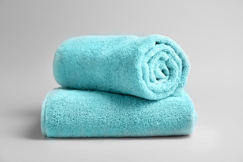 Soft bath towels on grey background