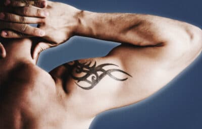 2020/10/Tattoo-Donts-for-Men-Man-Flexing-Bicep-with-Tribal-Tattoo-on-Shoulder.jpg