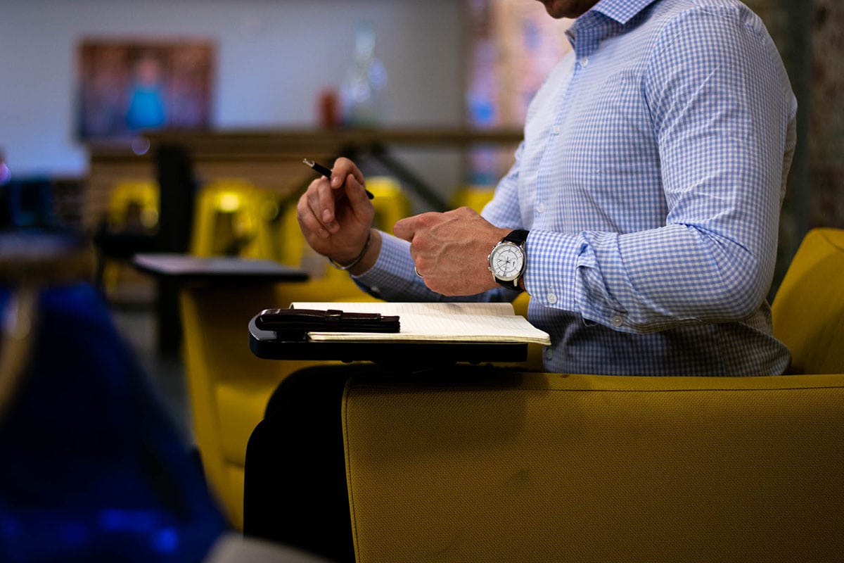 truwear blue checked shirt model in yellow chair with pen performance